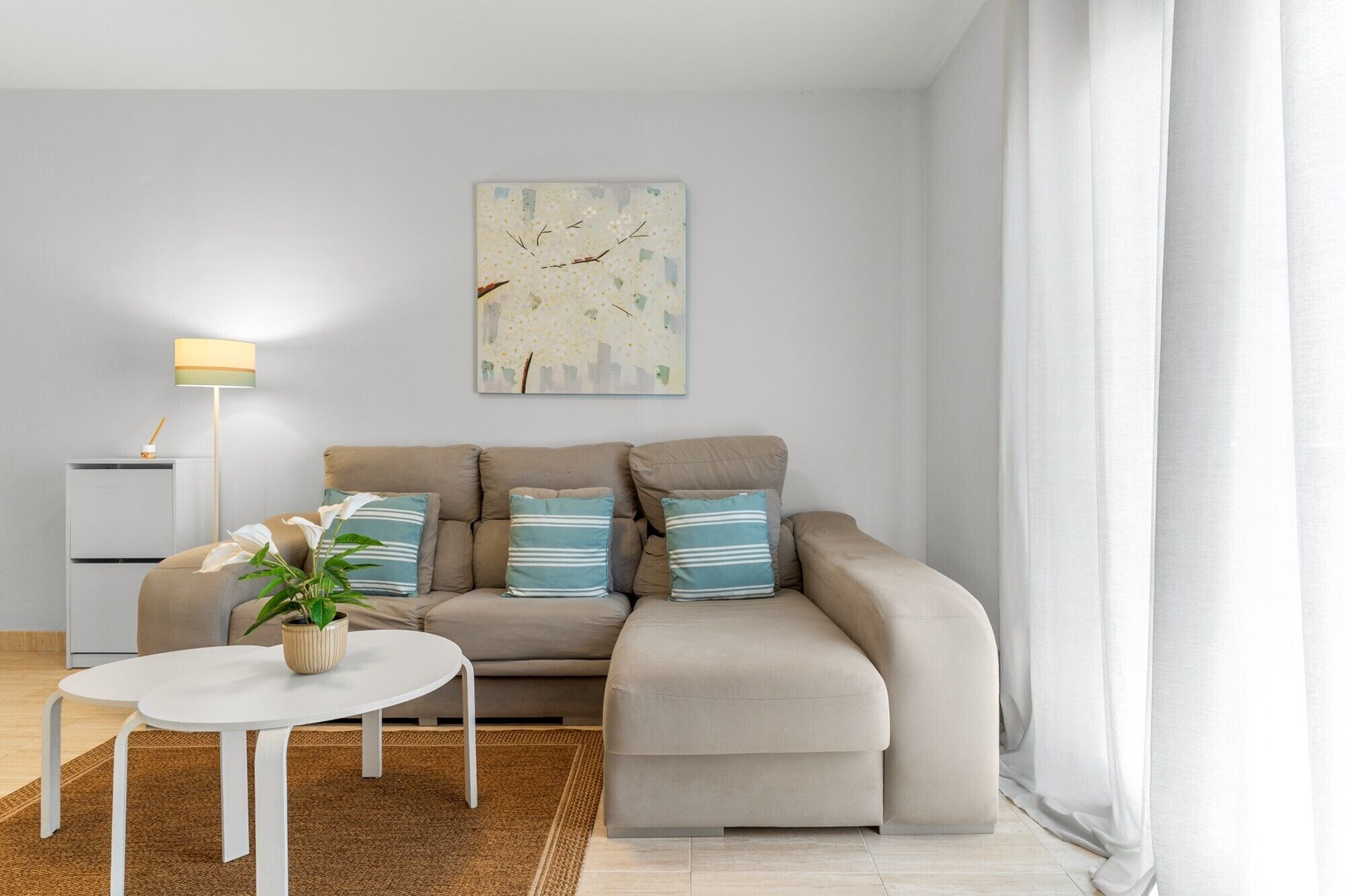 Un salon moderne avec un canapé, une petite table et une lampe.