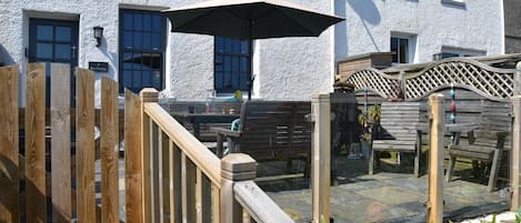 Une terrasse en bois avec des sièges d’extérieur et une pergola.