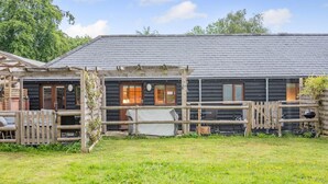 A rustic cabin with a wooden deck and a fenced yard. - 1 Bed in Blashford (oc-d32251) (Ringwood)