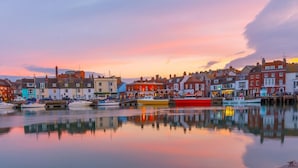 Un pueblo costero con edificios coloridos y barcos amarrados en el puerto.