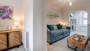 A modern living room with a sofa, coffee table, and artwork on the wall. - 2 Bed in Tenby (oc-c32240) (Tenby)