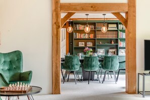 A dining area with a wooden ceiling, green upholstered chairs, and a chessboard on a table. - 4 Bed in Shadoxhurst (oc-c32123) (Shadoxhurst)
