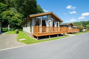 A single-story cabin with a wooden deck, a covered porch, and a stone foundation. - 2 Bed in Stepaside (oc-pw9184) (Stepaside)