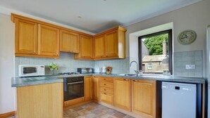 A kitchen with wooden cabinets, a microwave, stove, sink, and dishwasher. - 1 Bed in Cowling (oc-ds237) (Cowling)