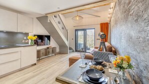 Une cuisine moderne avec un coin repas, un escalier et une grande fenêtre.