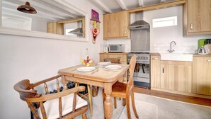 A kitchen with wooden cabinets, a stove, a microwave, and a sink. - 2 Bed in Whitby (oc-w353a) (Whitby)