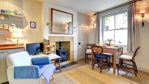 Una sala de estar acogedora con chimenea, comedor y televisor.