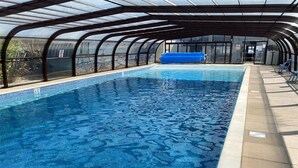An indoor swimming pool with a glass ceiling and a blue inflatable in the center. - 3 Bed in Corton (oc-s32347) (Corton)
