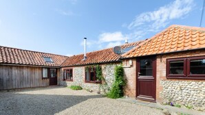 Ein rustikales Gebäude mit Kiesweg, Steinmauern und einem Ziegeldach.