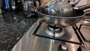 A kitchen with a stove, a pot, a pan, and a toaster. - Coventry Retreat - Modern 2 Bed Apartment (Coventry)