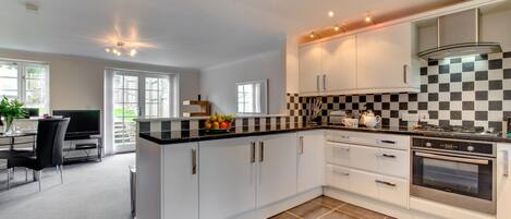 Ovn, oppvaskmaskin, høy barnestol og kjøkkenutstyr