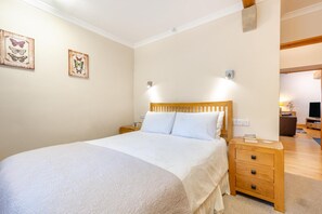 A bedroom with a wooden bed, white bedding, two wall-mounted nightstands, and two butterfly-themed wall art pieces. - 2 Bed in Cowling (oc-ds238) (Cowling)