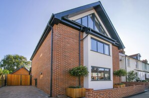 A modern two-story house with a brick exterior, a white upper floor, and a black roof. - 5 Bed in Southwold (oc-nort) (Southwold)