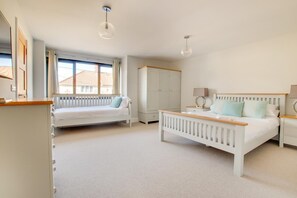 A bedroom with a bed, a daybed, a wardrobe, and a desk with a lamp. - 5 Bed in Southwold (oc-nort) (Southwold)
