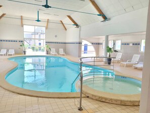 An indoor swimming pool with clear water, surrounded by lounge chairs and potted plants. - A peaceful retreat in Azay-le-Rideau—heated swimming pool (Azay-le-Rideau)