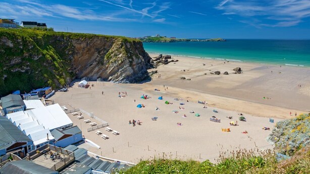 A beach with a rocky cliff, clear blue sky, and a sandy shore. - 1 Bed in Newquay (oc-o32401) (Holywell)