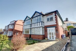 A two-story residential building with a brick facade, large windows, and a visible front door. - 6 Bed in Scarborough (oc-s871) (Scarborough)