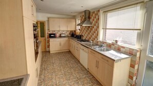 A kitchen with wooden cabinets, a tiled backsplash, a window with blinds, and a stainless steel sink. - 6 Bed in Scarborough (oc-s871) (Scarborough)