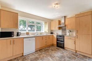 Een microgolfoven, een oven, een vaatwasser, kookgerei, borden en bestek