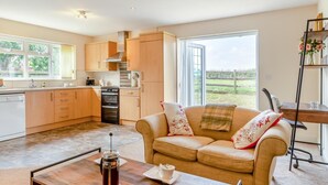 A modern kitchen with wooden cabinets, a built-in oven, and a large window offering a view of the outdoors. - 1 Bed in Flore (oc-b32437) (Flore)
