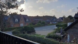 Ein Wohngebiet mit Häusern, einer Straße und blauem Himmel.