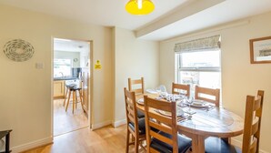A dining area with a round table, wooden chairs, and a yellow hanging light fixture. - 3 Bed in Whitby (oc-w957) (Whitby)