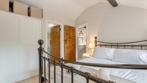 A bedroom with a bed, a wardrobe, and a wooden door. - 3 Bed in Alfrick (oc-s32386) (Alfrick)