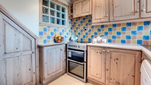 A kitchen with wooden cabinets, a tiled backsplash, a stove, and a window. - 2 Bed in Whitby (oc-w507) (Whitby)
