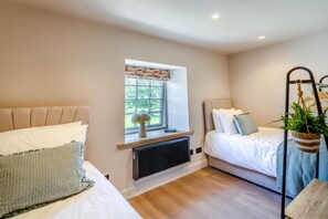 A bedroom with two beds, a window with a view, a radiator, and a hanging plant. - 5 Bed in Wigglesworth (oc-w32112) (Wigglesworth)