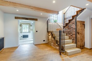 A staircase with a brick wall and wooden steps leading to a door. - 5 Bed in Wigglesworth (oc-w32112) (Wigglesworth)