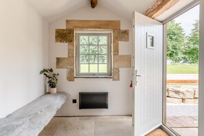 A room with a stone wall, a window, a radiator, a bench, and a door leading outside. - 5 Bed in Wigglesworth (oc-w32112) (Wigglesworth)