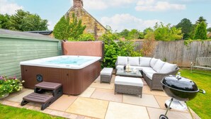 A backyard with a hot tub, outdoor furniture, and a grill. - 4 Bed in Scarborough (oc-sa870) (Scalby)