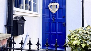 A blue door with a heart-shaped decoration, a mailbox, and a sign above the door reading "Sea Shell Cottage." - 2 Bed in Whitby (oc-w985) (Whitby)