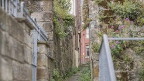 A narrow alleyway with stone walls, a metal fence, and a building in the background. - 2 Bed in Whitby (oc-w970b) (Whitby)