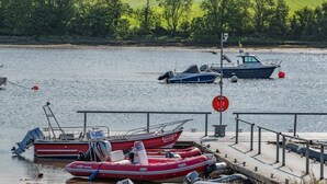 Una marina con imbarcazioni ormeggiate, una barca gonfiabile rossa e bianca e un piccolo motoscafo.