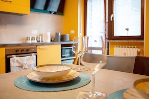 A dining table with a bowl, wine glasses, and a mat. - Apartment 'Maison De Doi - Chatillon' with Mountain View, Private Garden and Wi-Fi (Panorama)