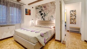 Ein Schlafzimmer mit einem Bett, einem Heizkörper, einem Holzboden und einem Bild an der Wand.