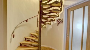 Eine Wendeltreppe mit modernem Design, Holzoptik und Metallgeländer.