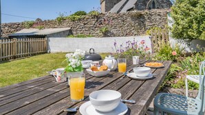 A wooden table set with breakfast items including croissants, a teapot, cups, and a glass of orange juice. - 3 Bed in Maudlam (oc-i32375) (Maudlam)