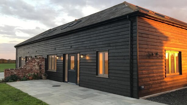 A modern building with a dark exterior, a brick entrance, and a paved driveway. - 2 Bed in Newton (oc-swro) (Newton)
