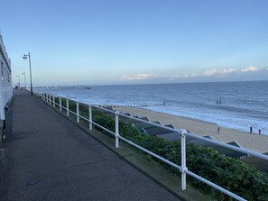 A coastal walkway with a railing, a beach, and the sea. - 2 Bed in Southwold (oc-4east) (Southwold)