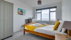 Una camera da letto con un letto, un armadio, una finestra e un quadro appeso al muro.