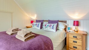 Ein Schlafzimmer mit einem Bett, zwei Nachttischen und einem Beistelltisch.