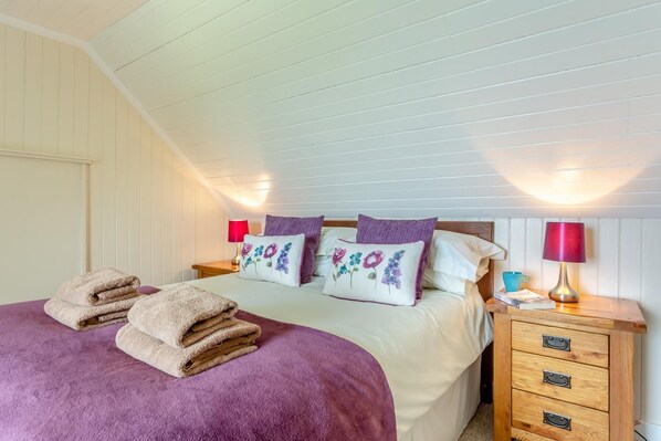 A bedroom with a bed, two bedside tables, and a nightstand.