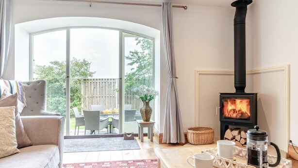 A cozy living room with a fireplace, a sofa, a coffee table, and a view of the outdoors. - 3 Bed in Cawton (oc-t32407) (Cawton)