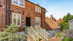 A brick house with a white front door, a small porch, and a satellite dish. - 2 Bed in Whitby (oc-w904) (Whitby)