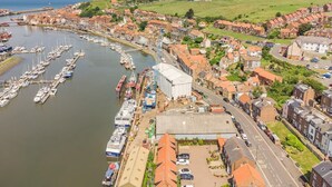A coastal town with a marina, residential buildings, and a prominent church. - 2 Bed in Whitby (oc-w904) (Whitby)