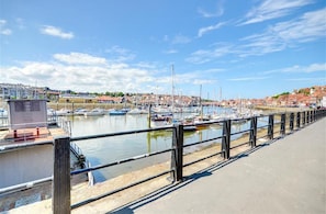 A marina with boats docked, a pedestrian walkway, and buildings in the background. - 2 Bed in Whitby (oc-w975) (Whitby)