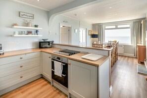 A compact kitchen with a microwave, oven, and wooden countertop. - 3 Bed in Praa Sands (oc-p00859) (Praa Sands)