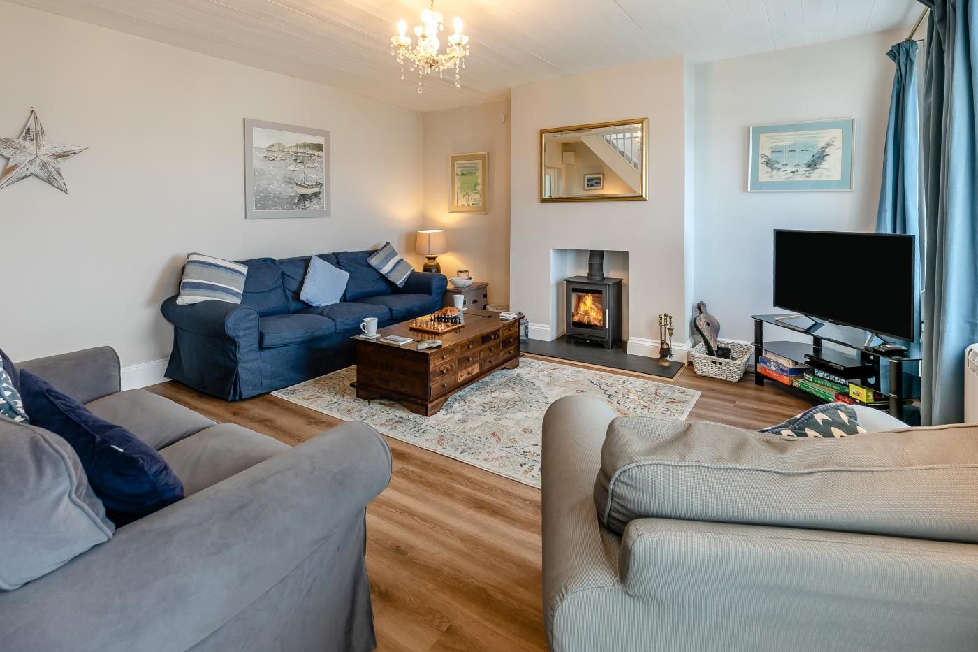 A cozy living room with a sofa, a coffee table, a fireplace, and a television.